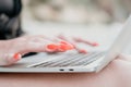 Successful business woman with bright red manicure typing on laptop keyboard outdoors on beach with sea view. Close up Royalty Free Stock Photo