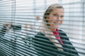 successful business woman looking through window blinds. Royalty Free Stock Photo