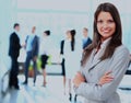 Successful business woman standing with her staff in background at office. Royalty Free Stock Photo