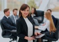 Successful business woman standing with her staff in background at office. Royalty Free Stock Photo