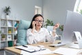 Successful business woman working in modern office, Asian woman talking on the phone, female worker wearing white shirt Royalty Free Stock Photo