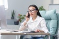 Successful business woman working in modern office, Asian woman talking on the phone, female worker wearing white shirt Royalty Free Stock Photo