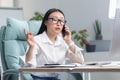 Successful business woman working in modern office, Asian woman talking on the phone, female worker wearing white shirt Royalty Free Stock Photo