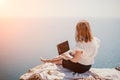 Woman sea laptop. Successful business woman working on laptop by the sea. Pretty lady typing on computer at summer day Royalty Free Stock Photo