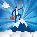 successful businessman with a briefcase and a flag on the top of the mountain symbolizing the world business among white clouds Royalty Free Stock Photo