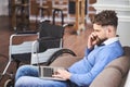 Successful businessman with disability sitting on a couch, working on a laptop Royalty Free Stock Photo