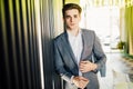 Successful businessman dressed in expensive suit is standing in hallway his company. Young male manager is posing in modern office Royalty Free Stock Photo