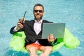 Successful businessman floating in suit in pool water. Summer vacations and travel concept. Funny business man drink Royalty Free Stock Photo