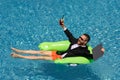 Successful businessman floating in suit in pool water. Summer vacations and travel concept. Funny business man drink Royalty Free Stock Photo