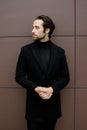 Successful businessman in formal stylish suit standing outside the office, looking at the side, posing for photography Royalty Free Stock Photo