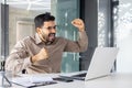 Successful businessman inside office celebrating victory and triumph, man reading happy news from laptop, entrepreneur Royalty Free Stock Photo