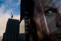 A successful businessman looks over construction of new industrial buildings. Double exposure of man face over commercial office Royalty Free Stock Photo