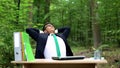 Successful businessman relaxing outdoors after hardworking, eco-friendly office Royalty Free Stock Photo