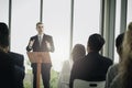 Successful businessman sharing experiences and giving a speech  group of business people sitting on conference together listening Royalty Free Stock Photo