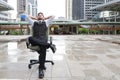 Successful businessman sitting on chair with relaxation on city blurred background