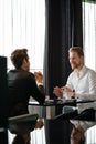 Successful businessman smiling while discussing with partner during meeting at coffee break Royalty Free Stock Photo