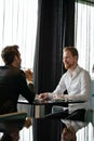 Successful businessman smiling while discussing with partner during meeting at coffee break Royalty Free Stock Photo