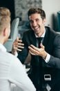 Successful businessman smiling while discussing with partner during meeting at coffee break Royalty Free Stock Photo