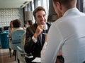 Successful businessman smiling while discussing with partner during meeting at coffee break Royalty Free Stock Photo