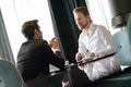 Successful businessman smiling while discussing with partner during meeting at coffee break Royalty Free Stock Photo