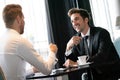 Successful businessman smiling while discussing with partner during meeting at coffee break Royalty Free Stock Photo