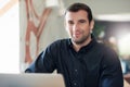 Successful businessman smiling and using a laptop in an office Royalty Free Stock Photo