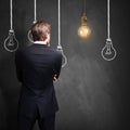 Successful businessman standing in front of a blackboard with lightbulbs, symbolizing having an idea Royalty Free Stock Photo