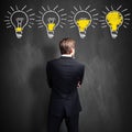 Successful businessman standing in front of a blackboard with lightbulbs Royalty Free Stock Photo