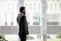 Successful businessman talking on phone, standing near window in office Royalty Free Stock Photo