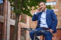 Successful businessman using telephone on bicycle