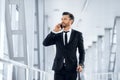 Successful businessman walking by airport, talking on phone Royalty Free Stock Photo