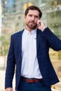 Successful businessman walking in the city talking on a cellphone Royalty Free Stock Photo