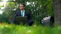 Successful businessman working with pleasure in park, sitting on grass, laptop Royalty Free Stock Photo