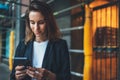 Successful businesswoman checks email on smartphone during a lunch break outside office, Manager uses mobile phone in city outdoor Royalty Free Stock Photo