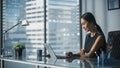 Successful Businesswoman in Stylish Dress Sitting at a Desk in Modern Office, Using Laptop Computer Royalty Free Stock Photo