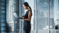 Successful Businesswoman in Stylish Dress Working on Laptop, Standing Next to Window in Big City Royalty Free Stock Photo