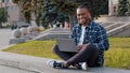 Successful busy african smiling man afro guy student male freelancer programmer designer in wireless headphones sitting