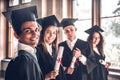 Successful careers - here we come!Group of smiling college graduates standing together in university and smiling looking at camera