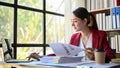 Successful Asian businesswoman focusing on reading financial report at her desk in the office Royalty Free Stock Photo