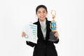 Successful cheerful young Asian business woman celebrating with trophy award over white isolated background. Success achievement Royalty Free Stock Photo