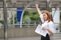 Successful cheerful young Asian businesswoman raising hands outside office. Thinking and thoughtful business concept Royalty Free Stock Photo