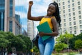 Successful cheering afro american female student with braids and backpack