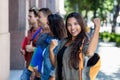 Successful cheering latin american female student with group of friends Royalty Free Stock Photo