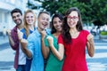 Successful cheering woman with glasses and young adult friends in line