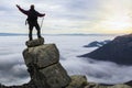 Successful climber climbing above fog clouds