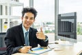 Successful confident asian businessman looking at camera, showing thumbs up or like while using laptop in office, recommending Royalty Free Stock Photo