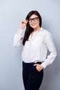 Successful confident young woman touching spectacles with hand i Royalty Free Stock Photo