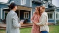 Successful Couple Striking Deal with Realtor in Front of Their New Home. Real Estate Agent Congr Royalty Free Stock Photo