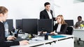 Successful coworkers engaged in business activities in busy open plan office