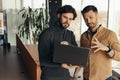 Focused male colleagues working on startup project together, discussing ideas, using computer at open space office Royalty Free Stock Photo